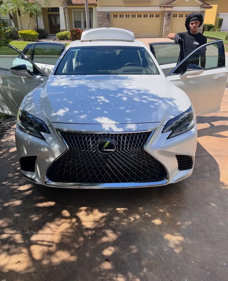 PureVisions detailer presenting a finished white Lexus LS