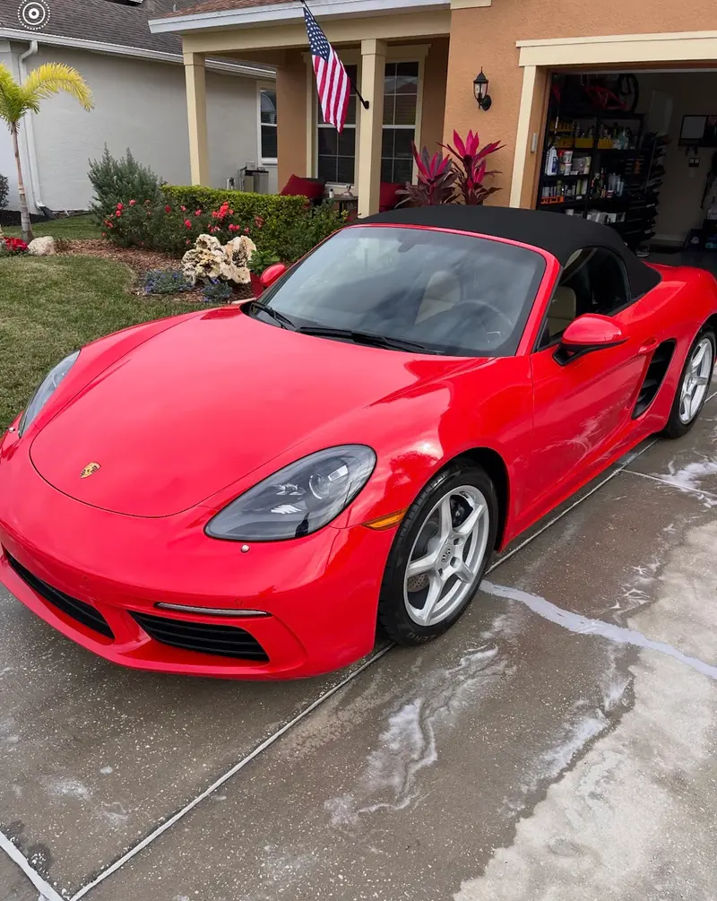 Freshly detailed red Porsche 718 Boxster in a Lakeland driveway